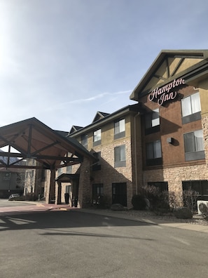 A Hampton Inn building with a stone facade, multiple windows, and a covered entrance area. - Hampton Inn Glenwood Springs (Glenwood Springs)
