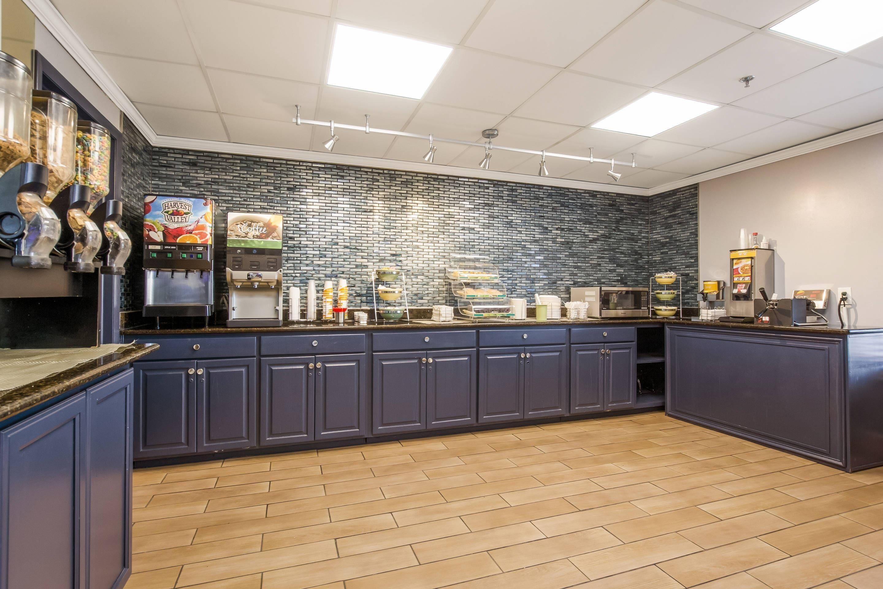 A commercial kitchen with a dark blue counter, a coffee machine, and a food display.