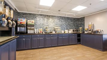 A commercial kitchen with a dark blue counter, a coffee machine, and a food display.