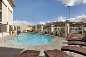 Una piscina al aire libre, sillones reclinables de piscina