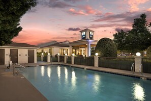 Una piscina al aire libre, sillones reclinables de piscina