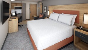 A hotel room with a large bed, a desk, a chair, a TV, and a kitchenette. - Candlewood Suites Dixon by IHG (Dixon)
