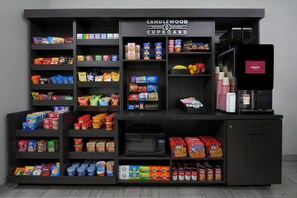 Quiosco de aperitivos y bebidas con gran variedad de opciones, incluyendo una máquina de caf é.