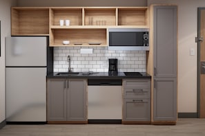 A modern kitchen with a built-in microwave, a coffee maker, and a refrigerator. - Candlewood Suites Dixon by IHG (Dixon)