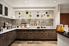 A modern kitchen with a breakfast bar, cabinets, and a wall-mounted plate rack. - Homewood Suites by Hilton Phoenix/Chandler (Chandler)