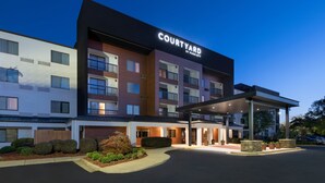 A Courtyard by Marriott hotel with a modern design, multiple floors, and a covered entrance area. - Courtyard by Marriott Burlington (Burlington)