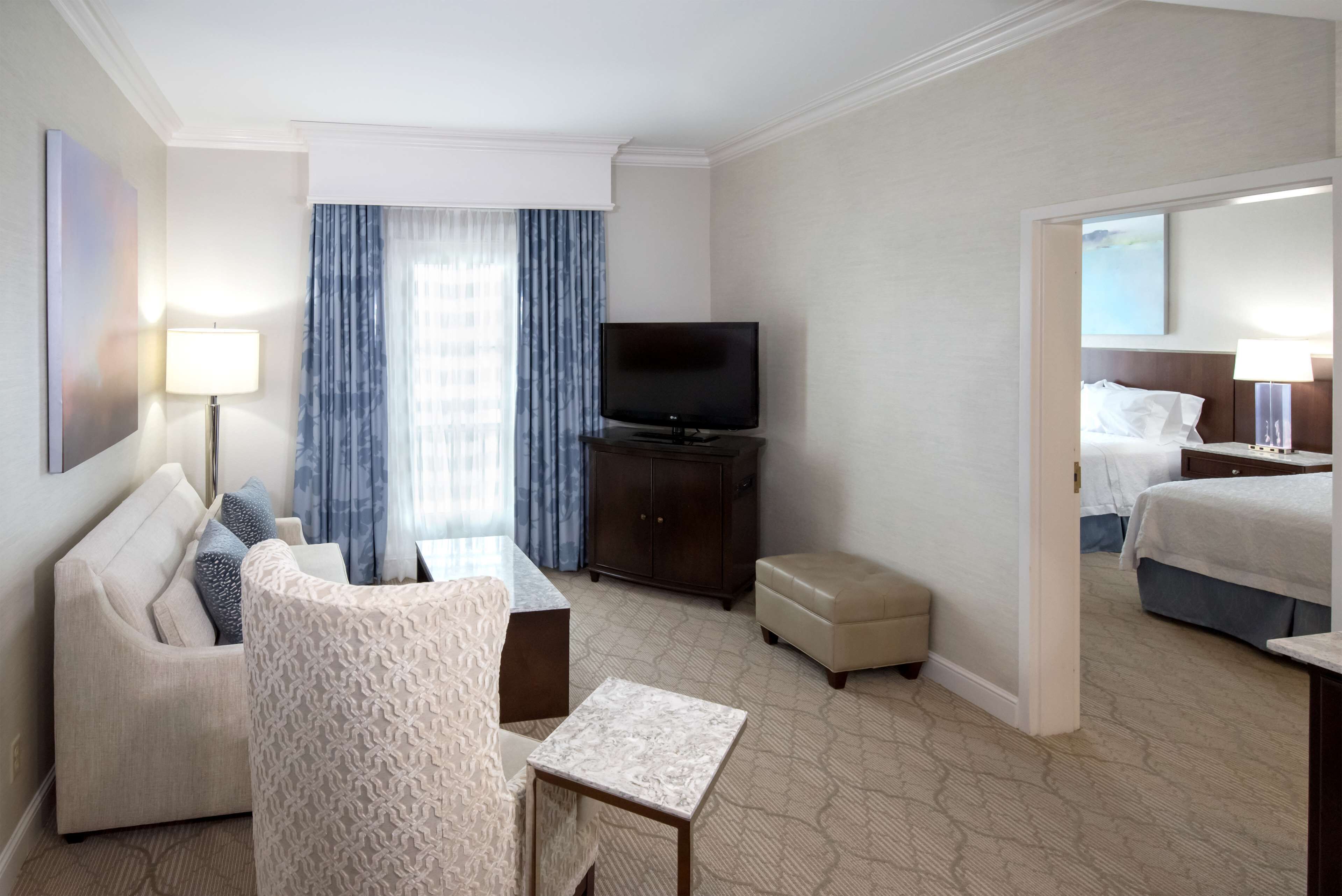 Een hotelkamer met een bank, een televisie, een tafeltje en een bed.