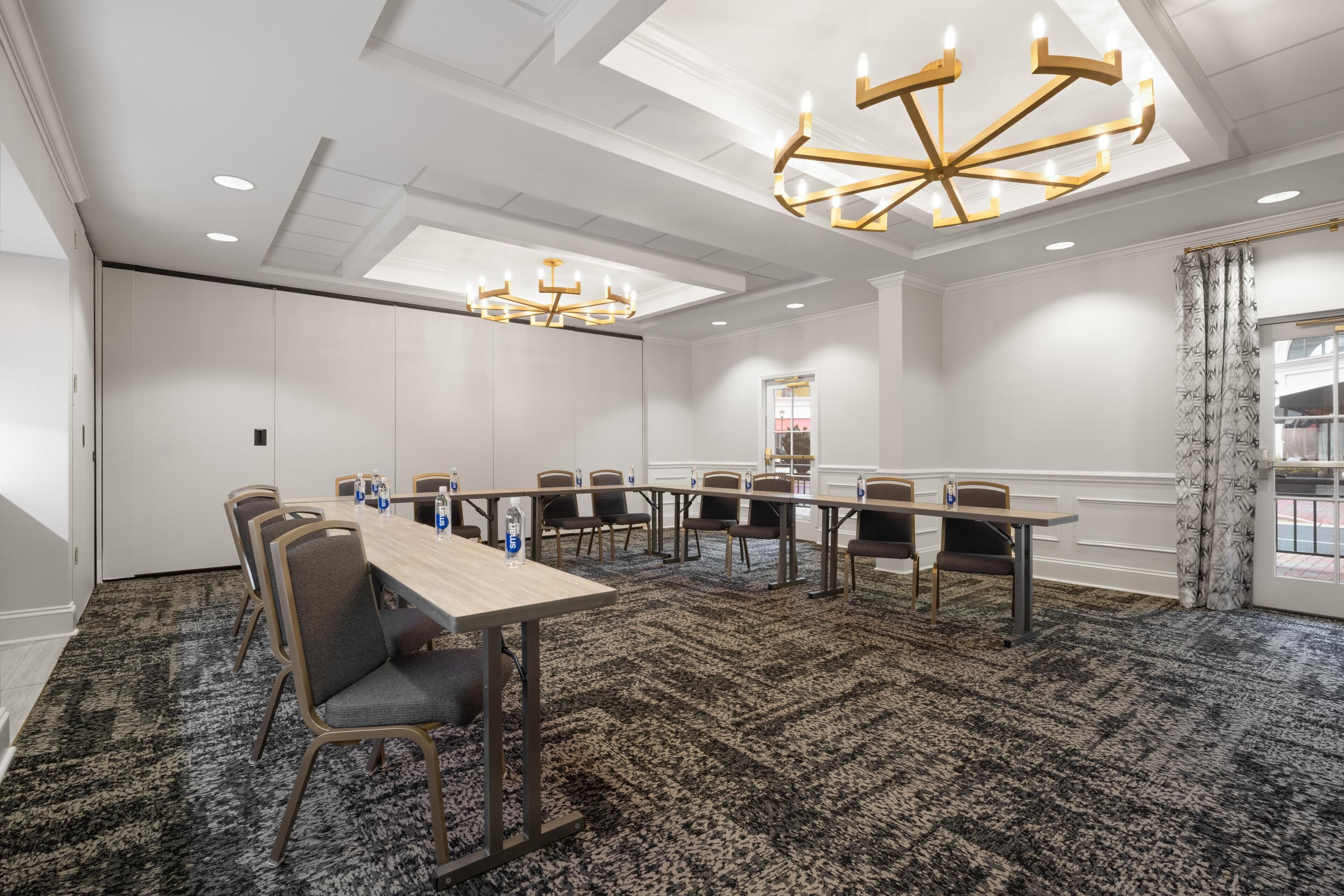 A conference room with a long table, chairs, and a chandelier.