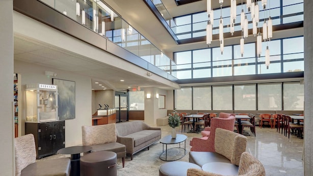 A spacious lobby with seating areas, a popcorn machine, and a high ceiling with natural light.