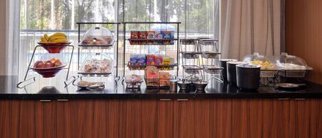 A breakfast buffet with various food items and a window view.