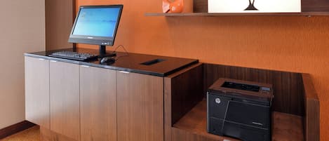 Un mostrador de recepción con un monitor de computadora, teclado e impresora HP.