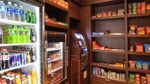 Ett kylt dryckesställ och hyllor fyllda med snacks och drycker.