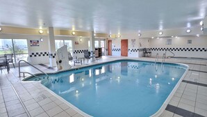 An indoor swimming pool with tiled floors, a lifeguard chair, and a pool ladder. - Comfort Inn & Suites Houston North - Spring (Houston)