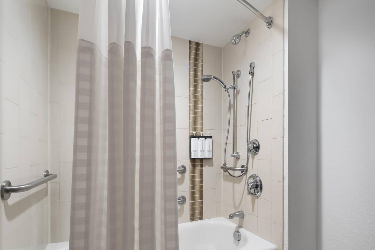 Une salle de bain avec une douche, une baignoire et des toilettes.