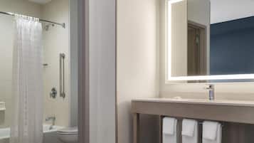 A modern bathroom with a shower, toilet, and vanity.