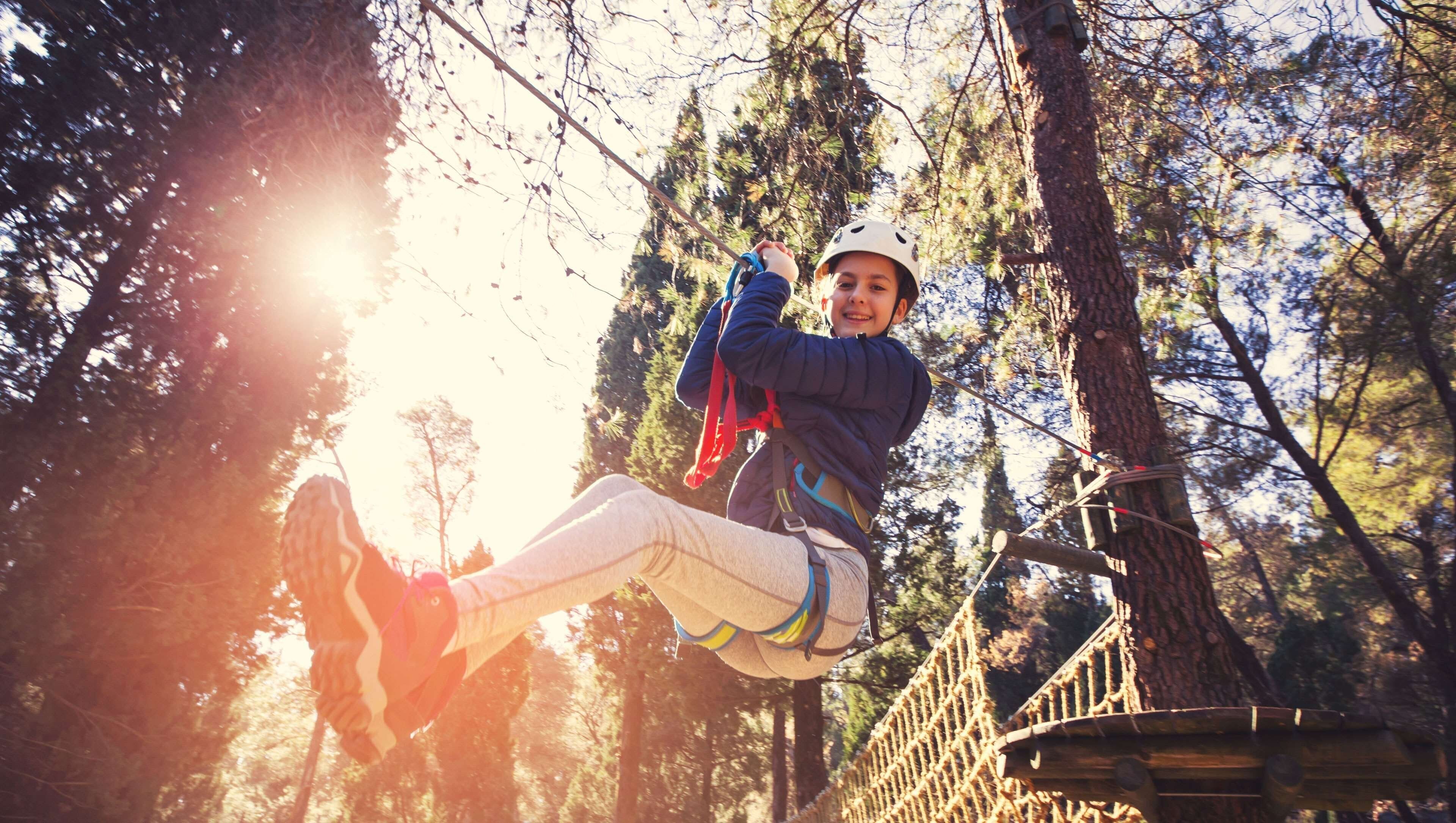 A person zip-lining through a forest.
