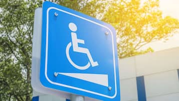 A blue handicap parking sign with a white wheelchair symbol.