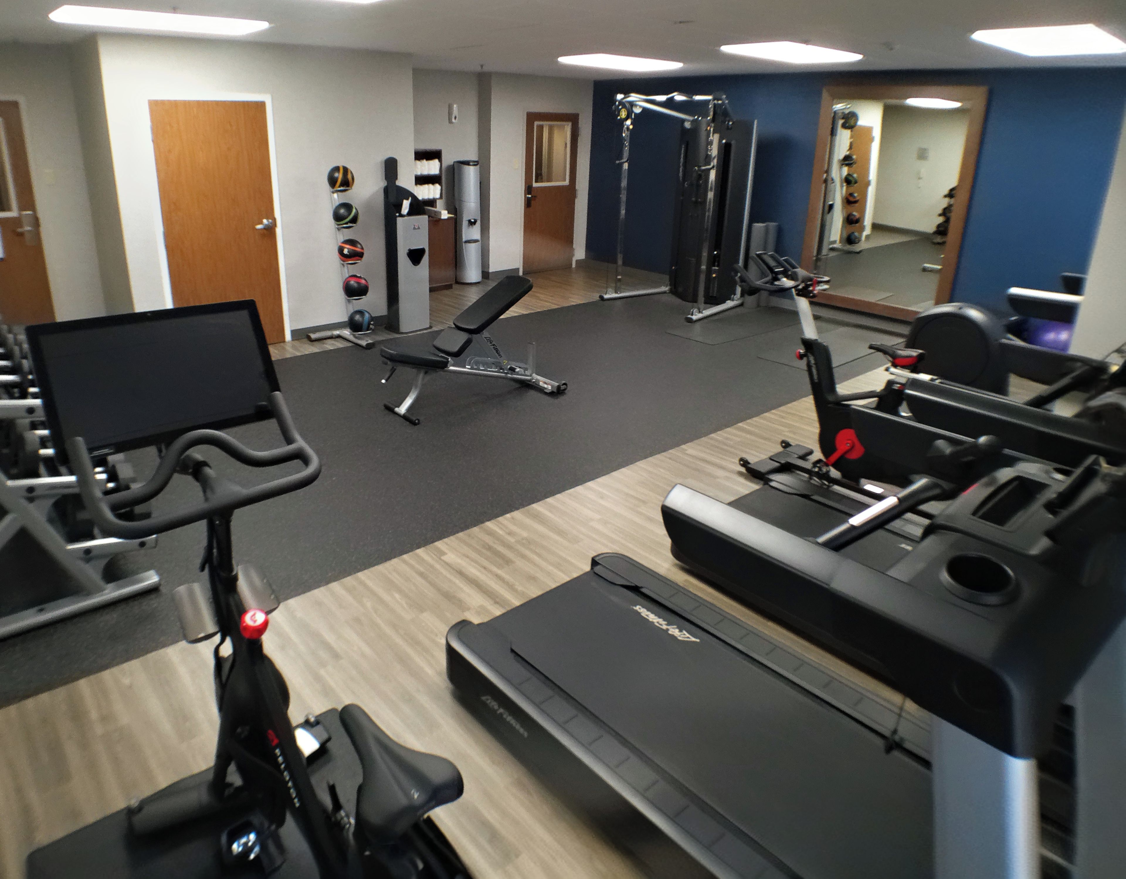 A gym with treadmills, a stationary bike, and a weight machine.
