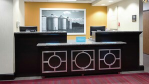A hotel reception desk with a large framed picture of silos and the word "dream." on the wall.