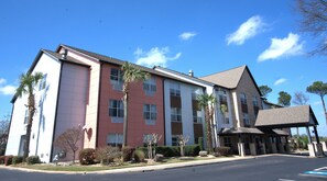 A multi-story hotel with a flat roof, large windows, and a covered entrance. - Baymont Inn & Suites by Wyndham Morrow/Atlanta I-75 South (Morrow)