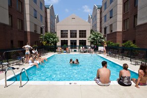 Una piscina al aire libre de temporada, sombrillas
