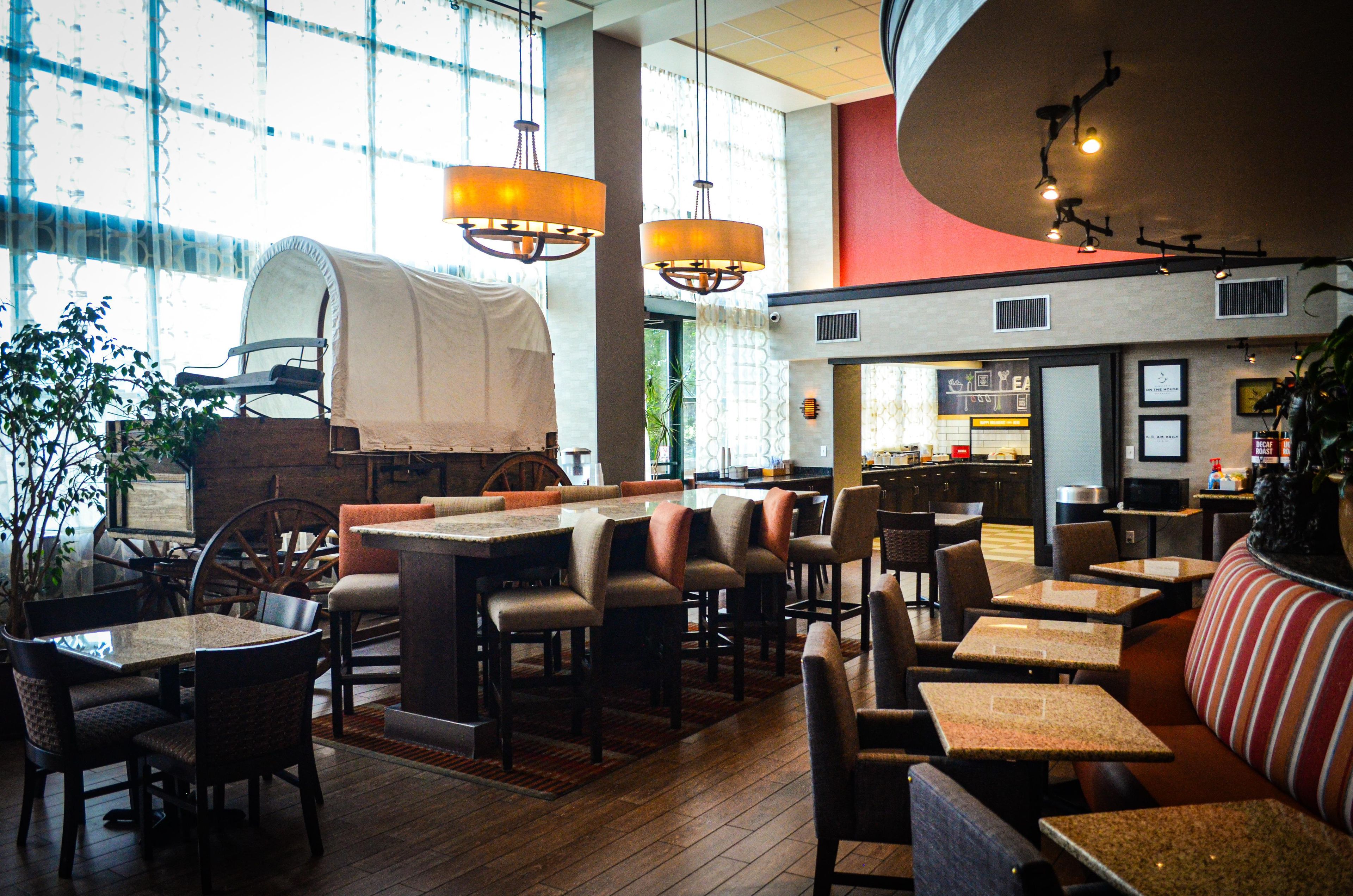A restaurant with a bar area, seating, and a kitchen visible through the windows.