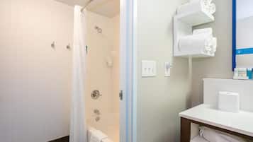 A bathroom with a shower, a toilet, a sink, and a towel rack.