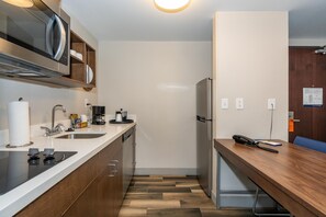 Una cocina moderna con horno empotrado, microondas y pileta de acero inoxidable.