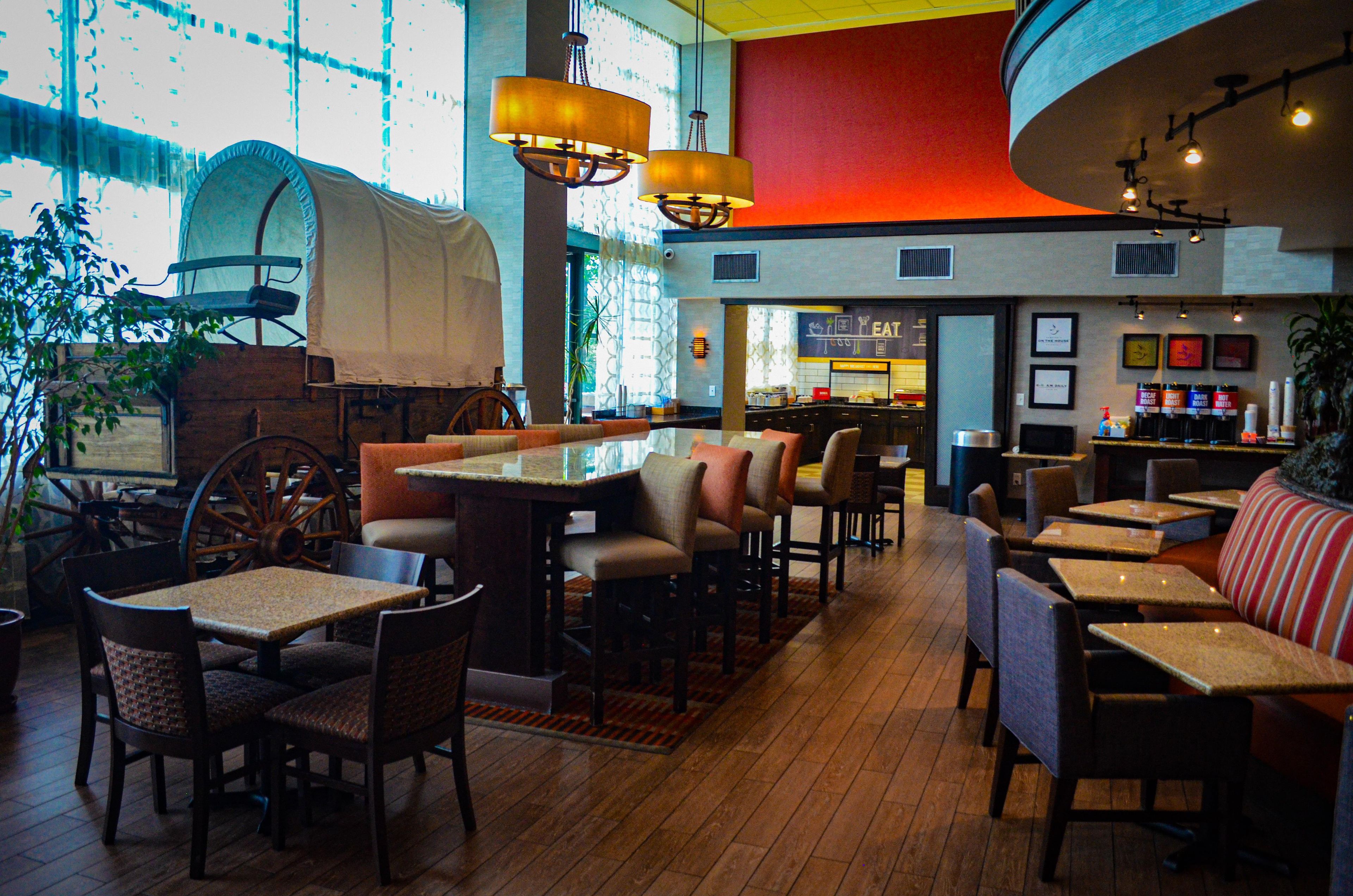 Un restaurant doté d’un plancher en bois, de tables, de chaises et d’un bar.