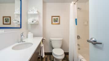 Et badeværelse med vask, toilet og bruser.
