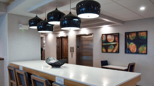 A modern hotel lobby with a central island, seating area, and artwork on the walls. - Hampton Inn Frankfort (Frankfort)