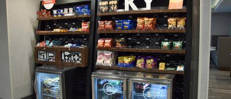 A snack display with various packaged foods and two beverage refrigerators.