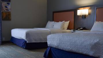 Une chambre d’hôtel avec deux lits, chacun doté d’une tête de lit et d’une lampe de chevet.
