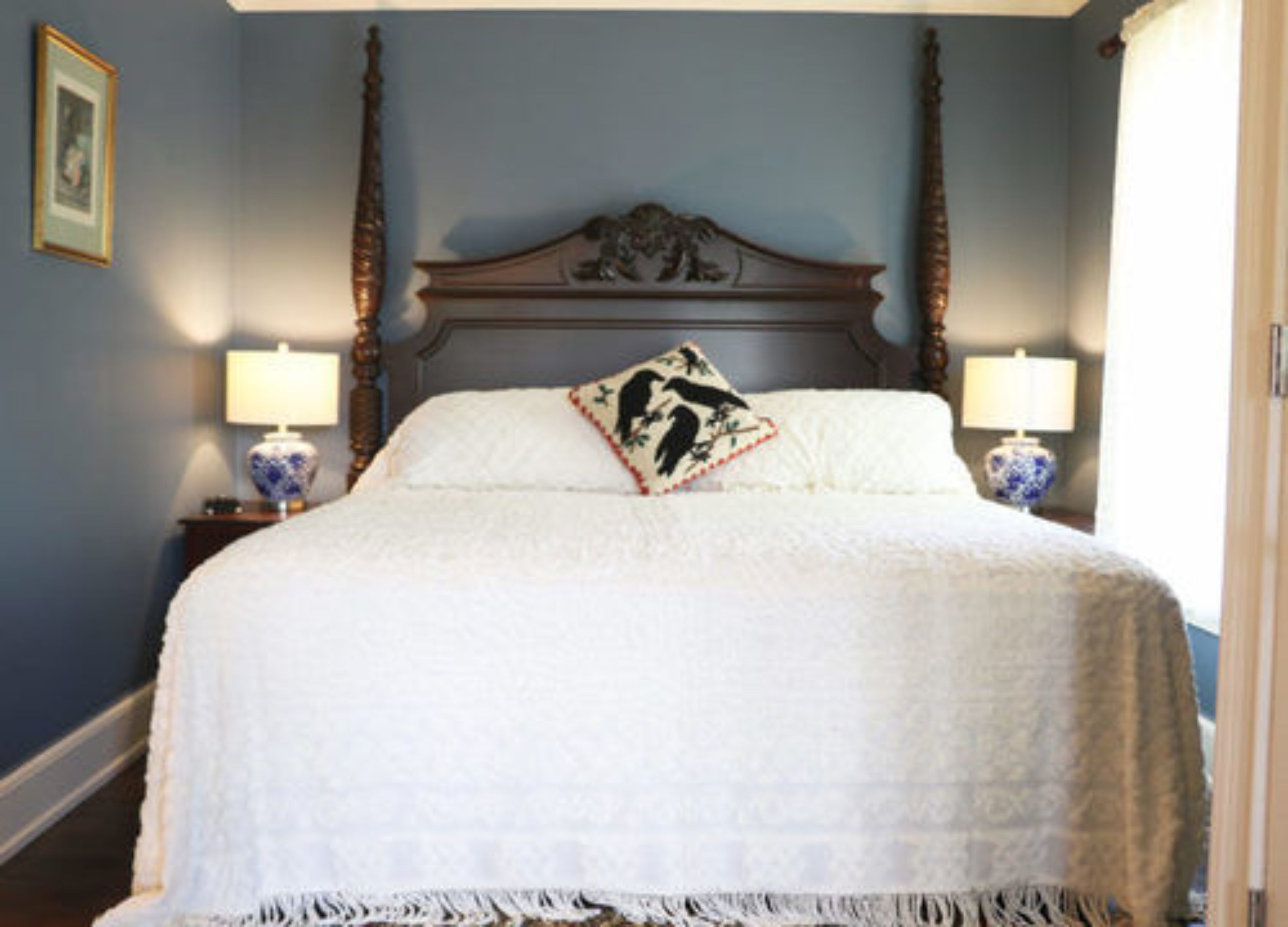 A bedroom with a large bed, two bedside tables with lamps, and a decorative headboard.