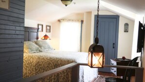 Ein Schlafzimmer mit einem Bett, einem hängenden Laternen, einem Stuhl und einem Schreibtisch.