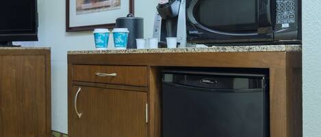 Una kitchenette equipada con microondas, cafetera y lavavajillas.
