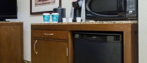 A kitchen with a microwave, coffee maker, and dishwasher.