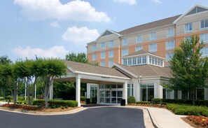 A multi-story hotel with a covered entrance, clear signage, and landscaped surroundings. - Hilton Garden Inn Atlanta North/Alpharetta (Alpharetta)