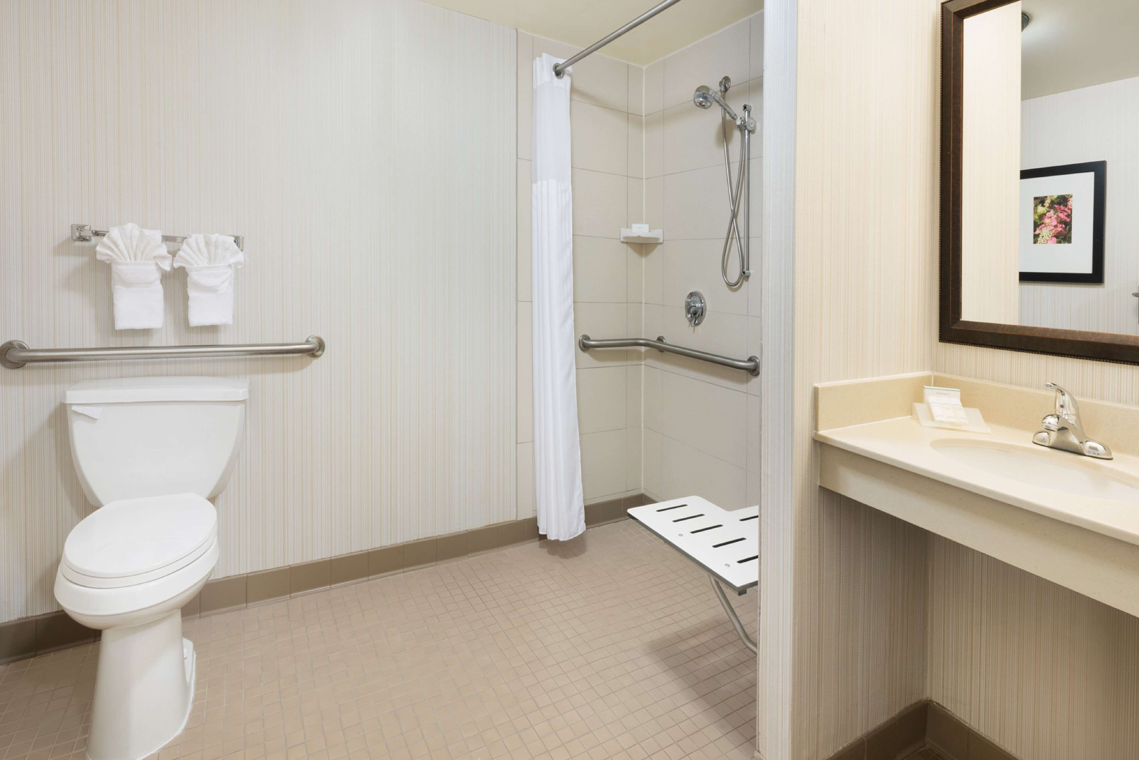A bathroom with a toilet, shower, and sink.