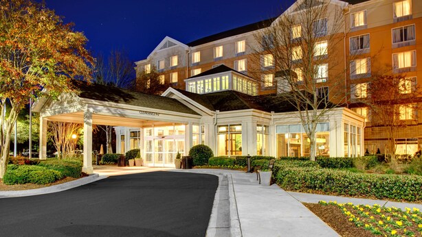A hotel with a covered entrance, multiple floors, and a well-lit facade. - Hilton Garden Inn Atlanta North/Alpharetta (Alpharetta)