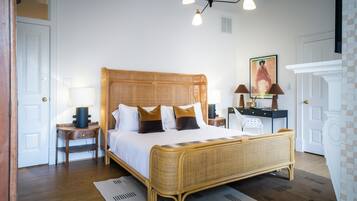 A bedroom with a large bed, bedside tables, a lamp, and a painting on the wall.