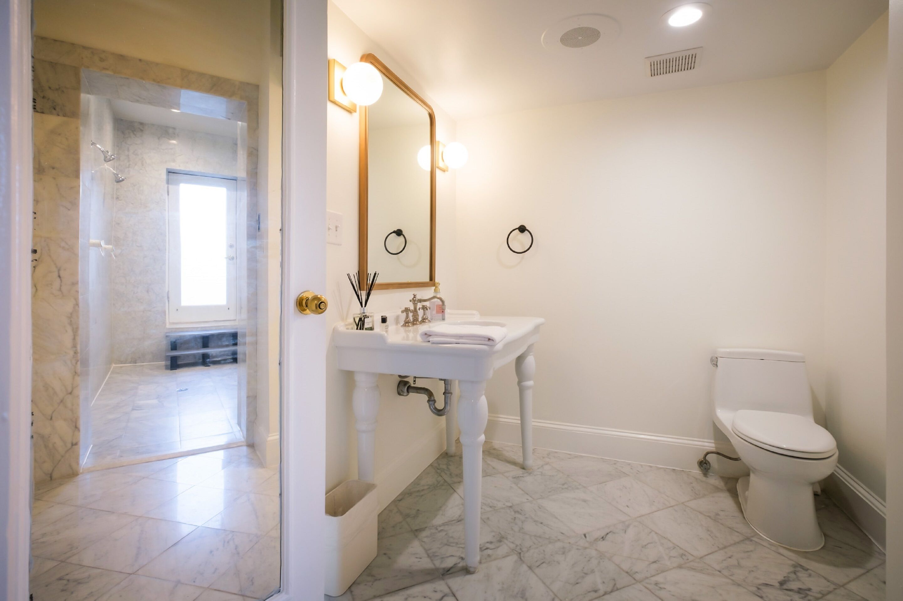 A bathroom with a white sink, a toilet, and a glass shower enclosure.