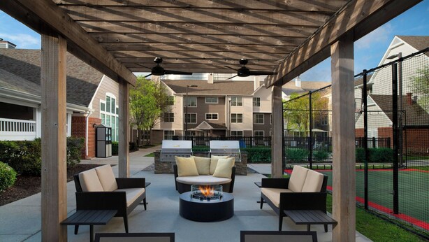 Une terrasse extérieure avec un foyer, des sièges et un barbecue.