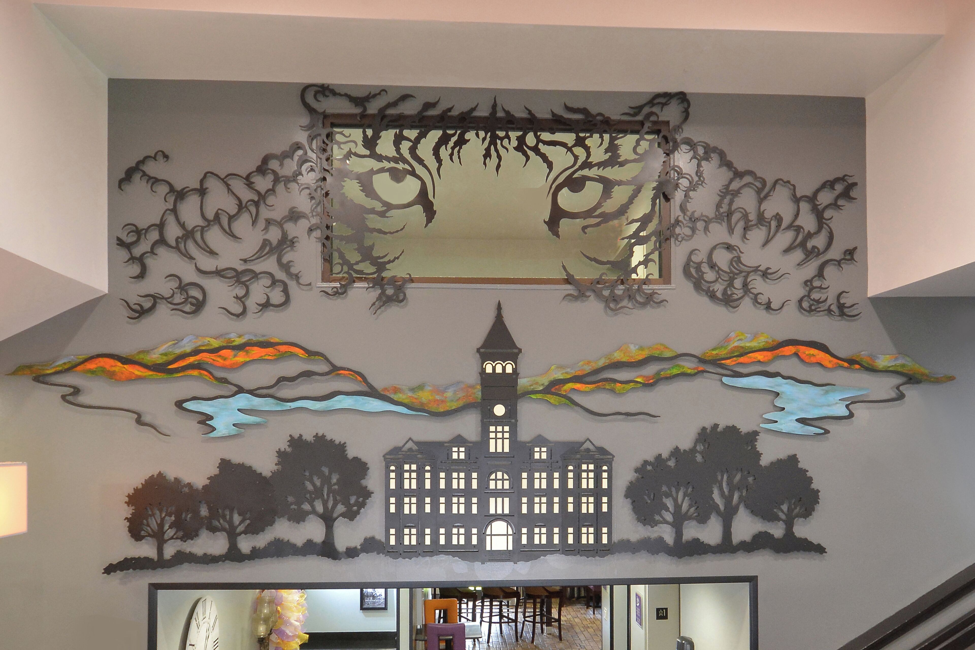 A wall with a large, central artwork featuring a face with eyes and a clock tower.