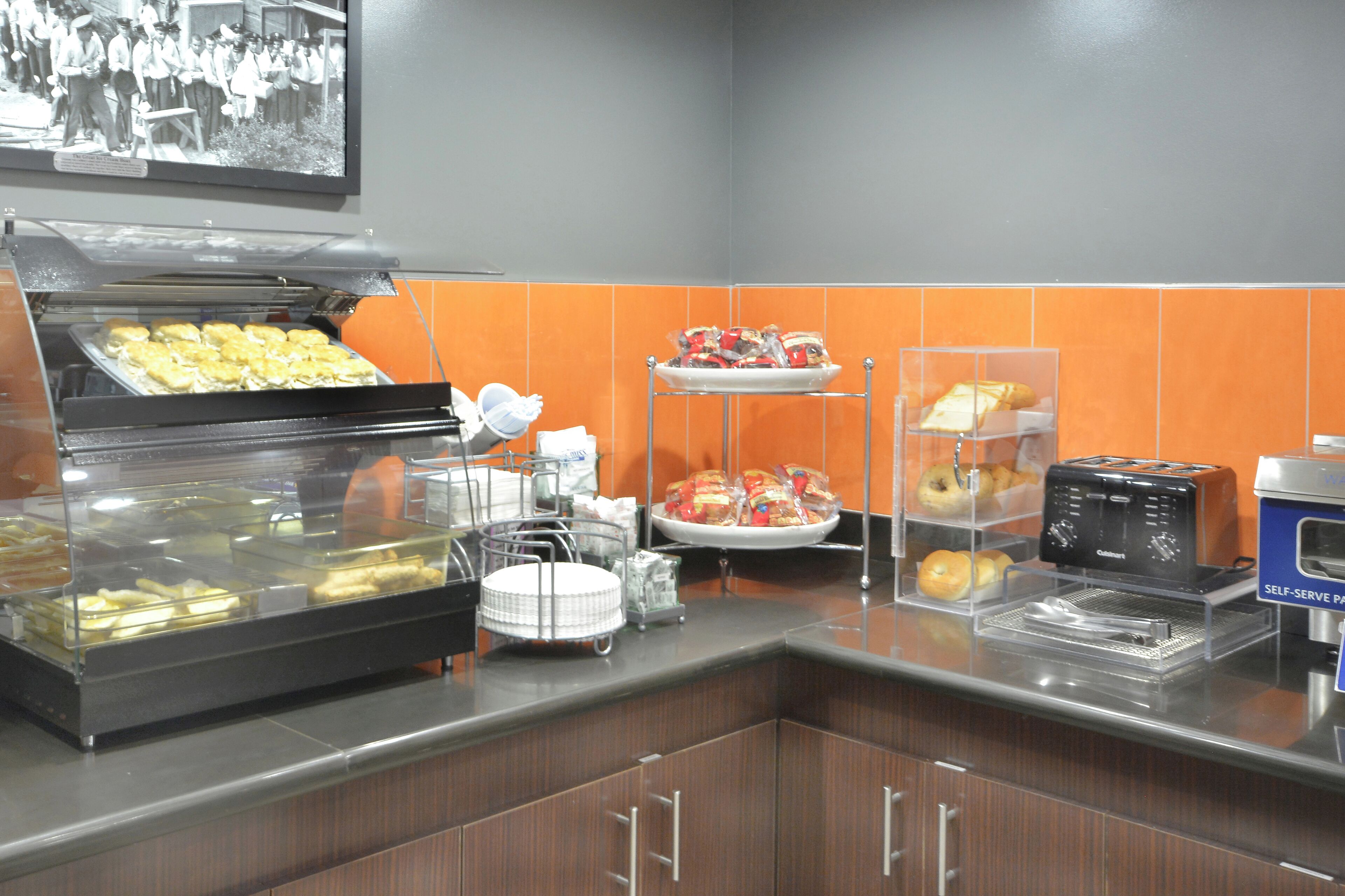 A self-serve breakfast station with various food items and a toaster.