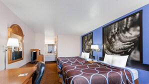 A hotel room with a bed, desk, chair, and a large mirror. - Super 8 by Wyndham Cleburne (Cleburne)