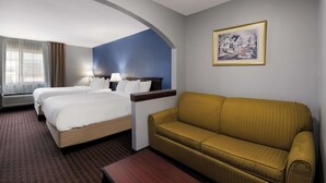 Ett hotellrum med två sängar, en soffa, en inramad tavla på väggen och ett fönster med gardiner.