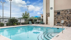 A pool area with a no diving sign, lounge chairs, and a stone wall. - Hampton Inn Douglas (Douglas)