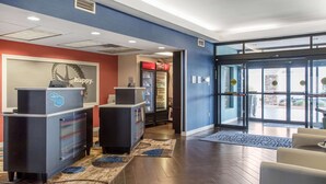 A reception area with a desk, a Coca-Cola refrigerator, and a large glass door entrance. - Hampton Inn Douglas (Douglas)