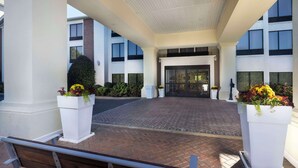 A hotel entrance with a brick pathway, white columns, and potted plants. - Comfort Inn & Suites Dahlonega University Area (Dahlonega)